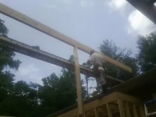 Carpenter setting a ridge beam over a new addition frame — Ice Dam Removal by Roofing Brothers in Valley View
